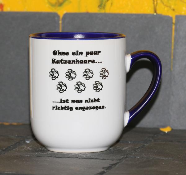 Weiße Tasse mit Spruch  "OHNE EIN PAAR KATZENHAARE, IST MAN NICHT RICHTIG ANGEZOGEN"
